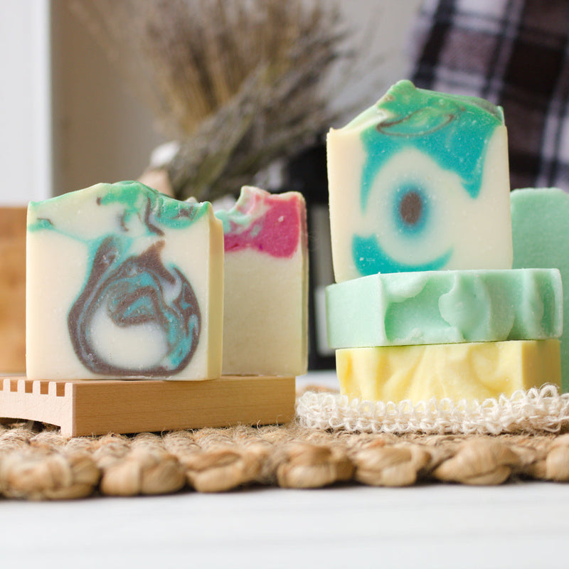 Handmade soaps of different colors in two stacks.