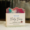 Handmade soap bar with 'Flirty Berry' label on a textured surface