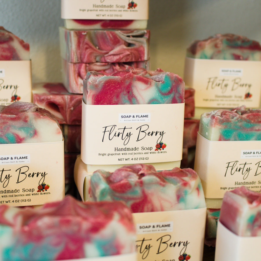 Handmade soap bars with 'Flirty Berry' label in a display setting
