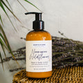 Hand and body lotion bottle labeled Norwegian Wildflowers on a woven mat with lavender.