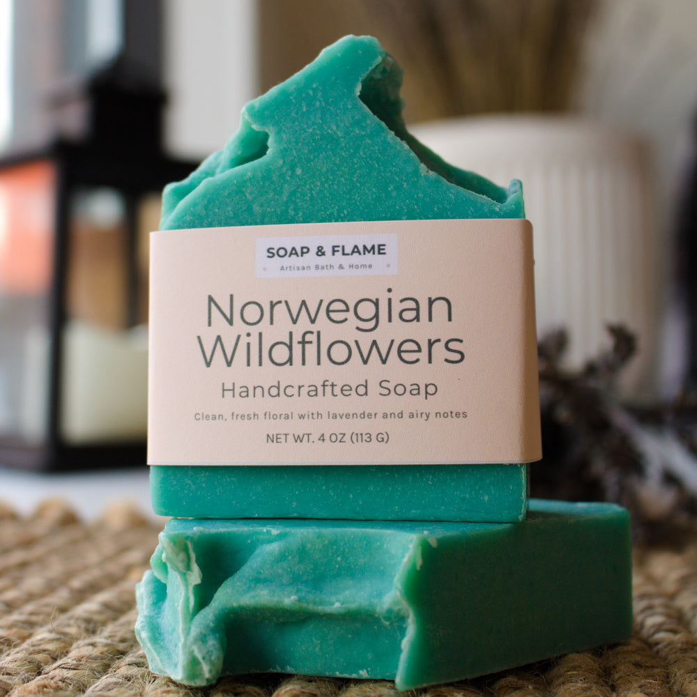 Two green bars of soap with a 'Norwegian Wildflowers' label on a woven surface.