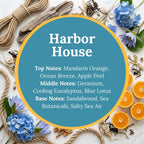 Harbor House scent infographic: top notes of mandarin orange, ocean breeze, and apple peel; middle notes of geranium, cooling eucalyptus, and blue lotus; base notes of sandalwood, sea botanicals, and salty sea air, over a coastal flat-lay of rope, driftwood, shells, and blue hydrangea.